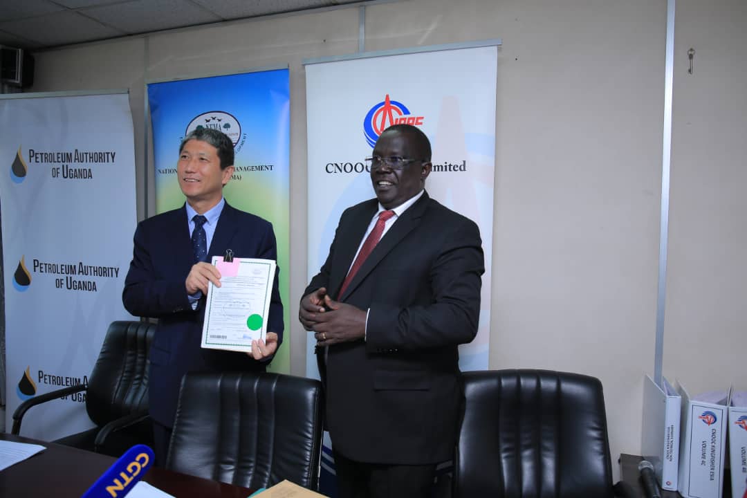 Zhao Shunqiang, the President, CNOOC Uganda Limited receives the certifcate from Tom Okurut (R), NEMA ED