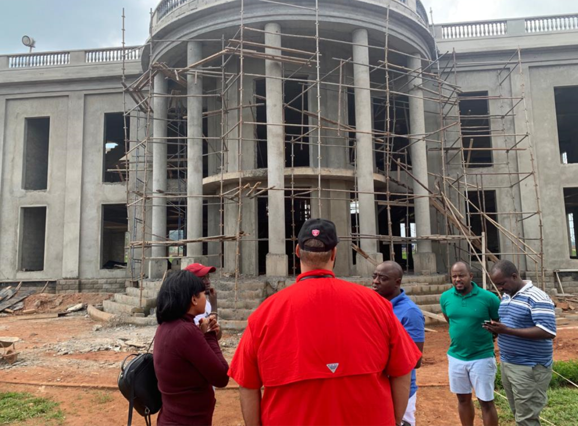 Ashworth in Red with Ham Kiggundu inspecting some of Ham's real estate constructions