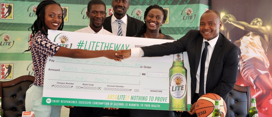 UBL's Cathy Twesigye (Left) hands over a dummy cheque to FUBA officials. Photo by Thomas Odongo 