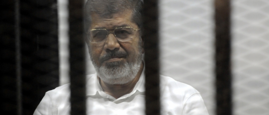 Egypt's ousted Islamist President Mohamed Morsi sits in the defendant cage in the Police