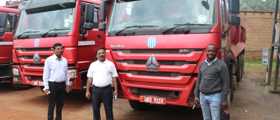 Minister Peter Ogwang (R) receiving 20 trucks from Dott Services Limited