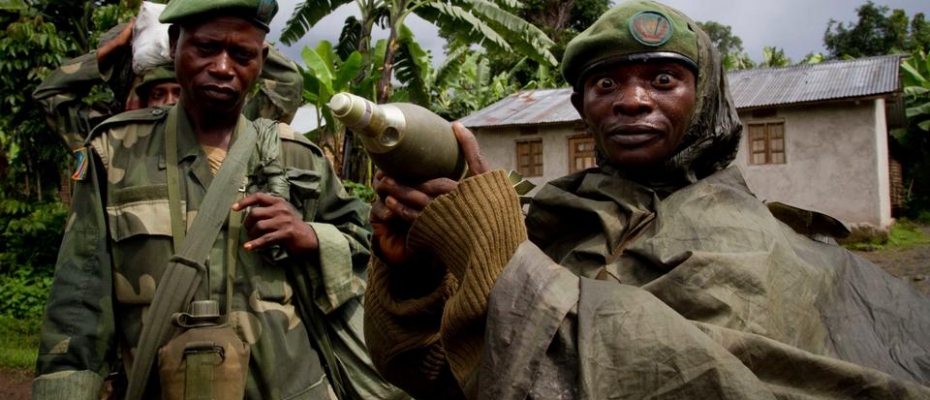 In this May 17, 2012 file photo, a Congolese government army soldier displays a mortar round after his unit returned from fighting against rebel forces, in Kinyamahura, Democratic Republic of Congo. 