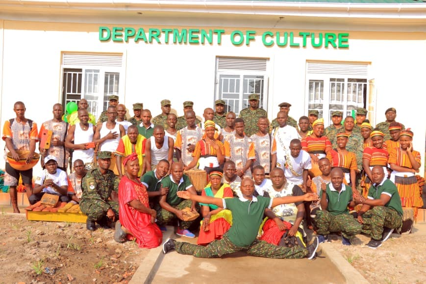 Cultural performers and staff having a group photo after receiving a new administration block.