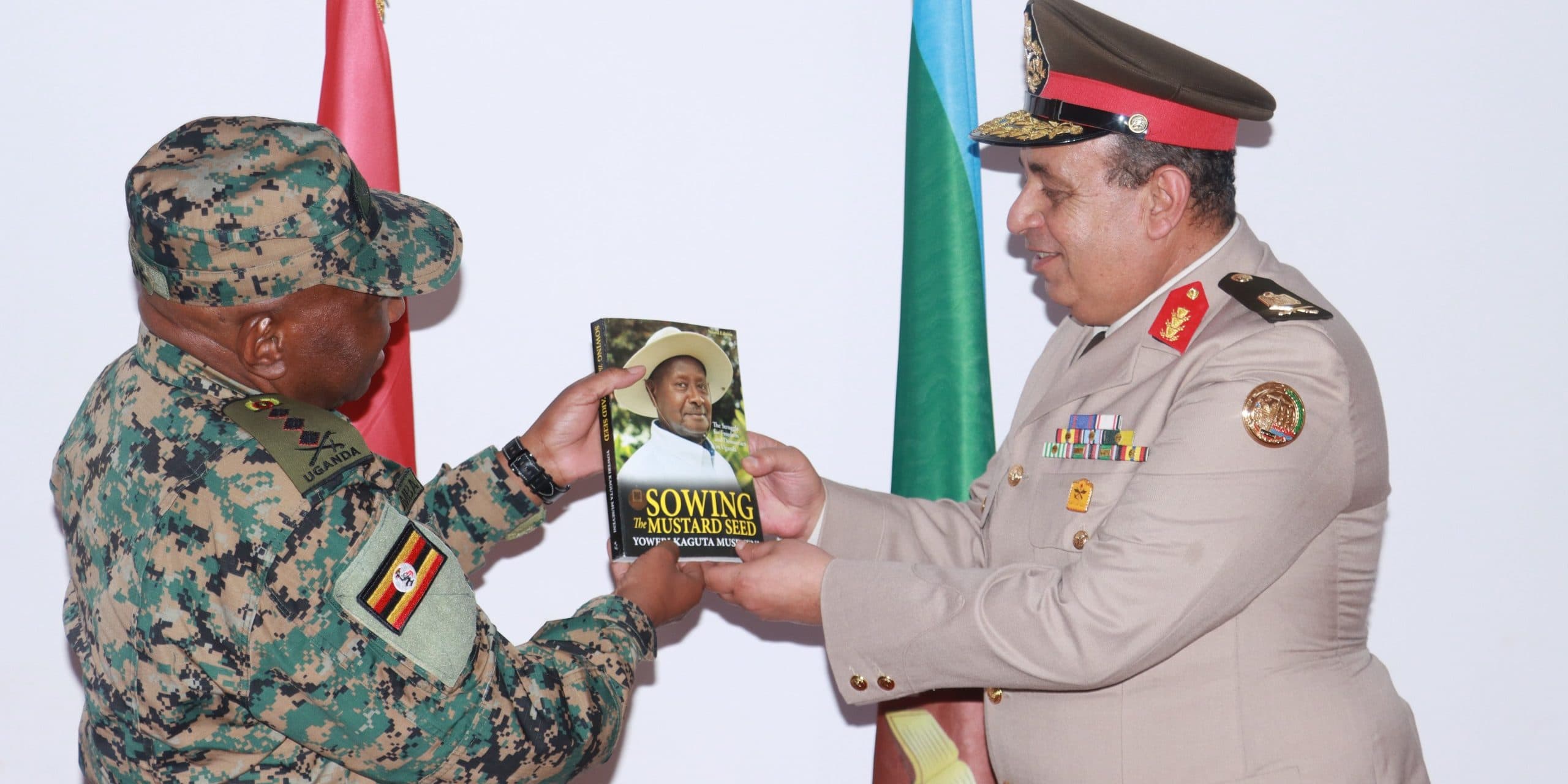 Lt Gen Jack Bakasumba gives a mastered seed to Maj Gen Khalid Ismael Taha.