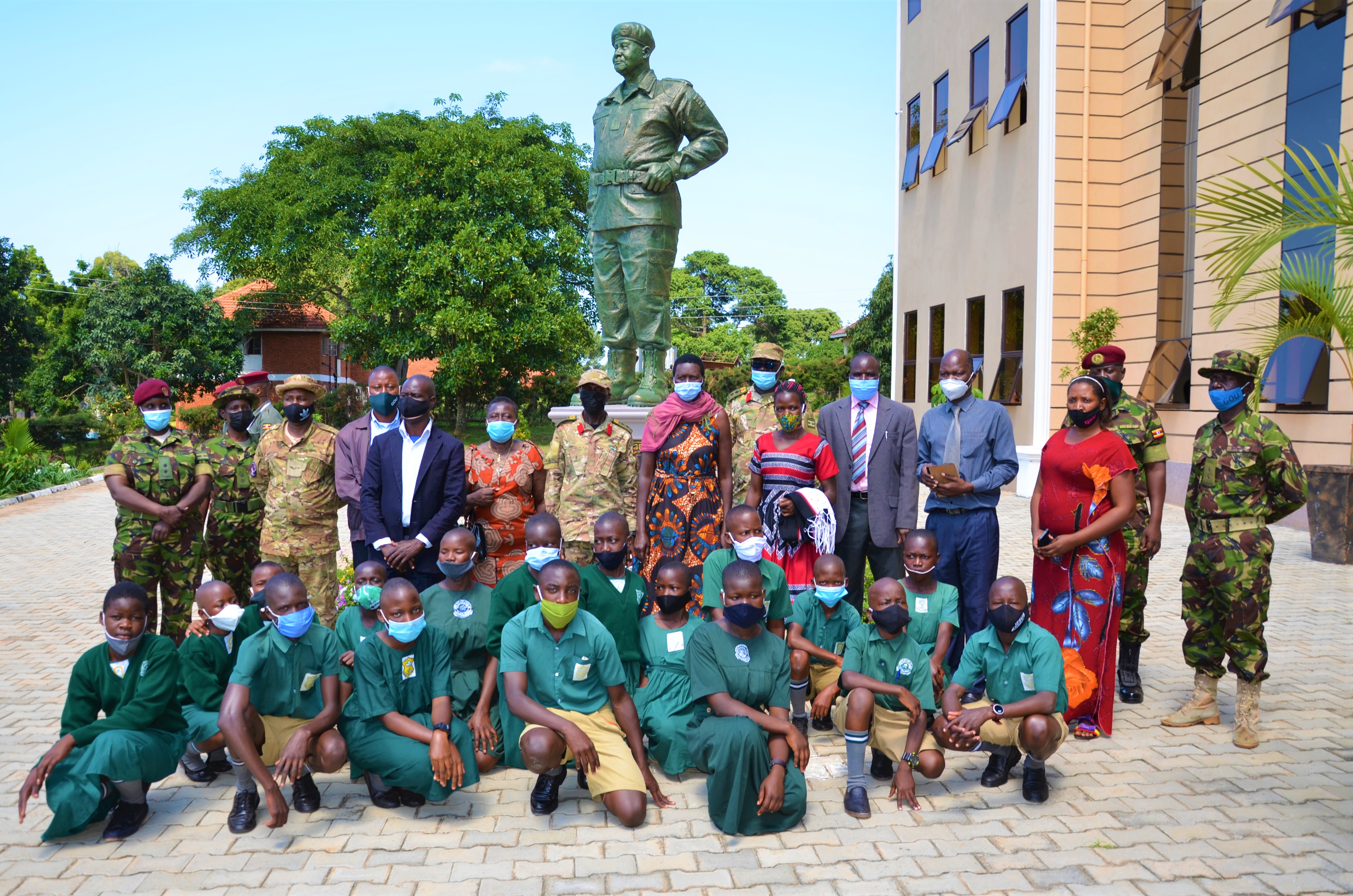 The pupils poses with SFC soldiers in front of Gen Museveni's monument at the SFC Headquarters. 