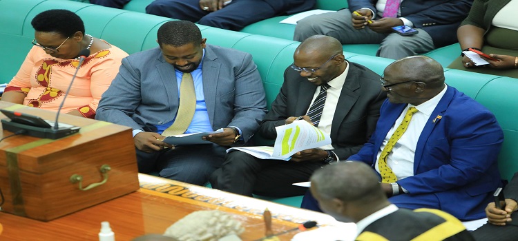 Works Minister Katumba Wamala (R), Deputy Attorney General Jackson Kafuuzi (C) and Committee Chairperson Dan Kimosho confer during the debate on the bill