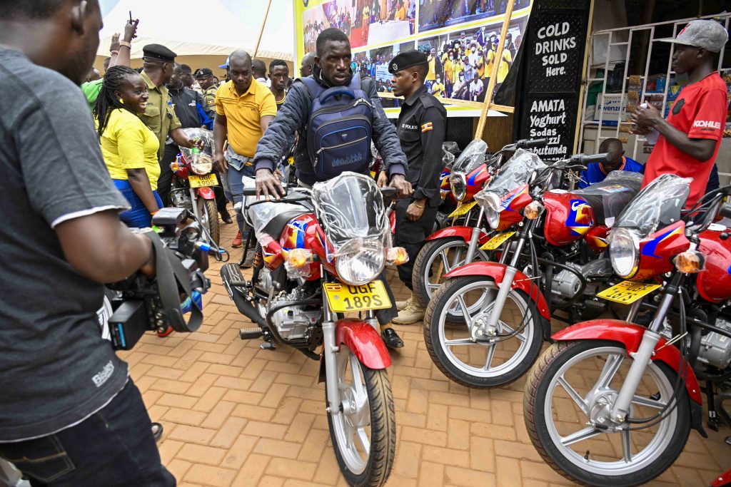 One of the beneficiaries moves away with one of the 36 boda bodas that are going to be received bythe 12 SACCOS in the Kampala Ghetto Structures each receiving 3 bikes 