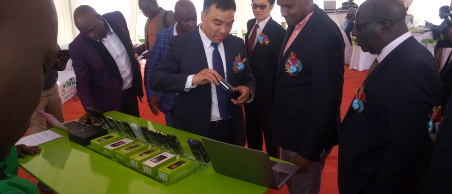 ICT minister Frank Tumwebaze inspects some of the locally manufactured phones by SIMI Mobile.