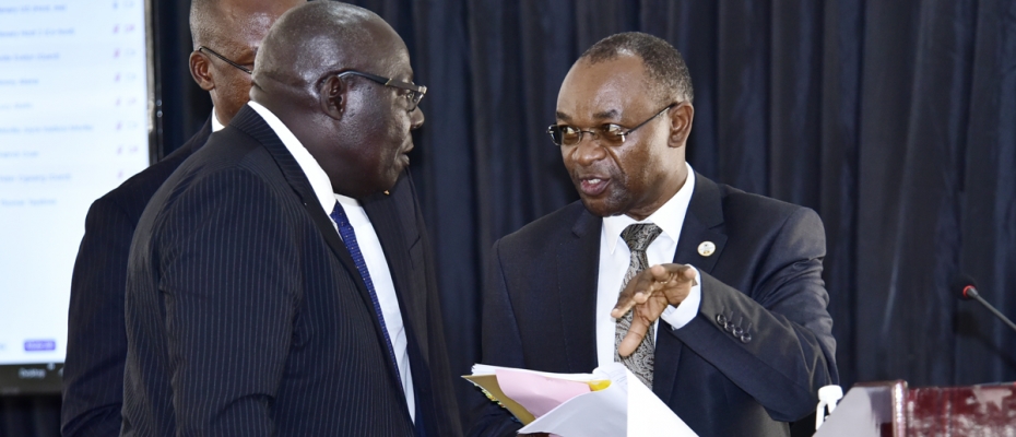 Local Government Minister, Raphael Magyezi (right) confering with MPs on the new cities 