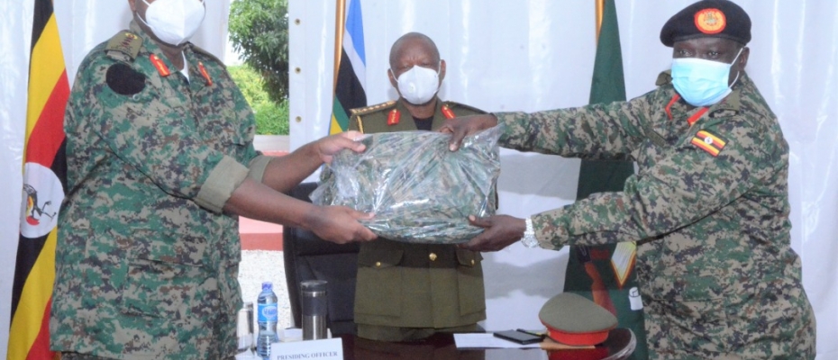 Gen Kainerugaba receiving the Land Forces Uniform from former CLF Lt Gen Peter Elwelu