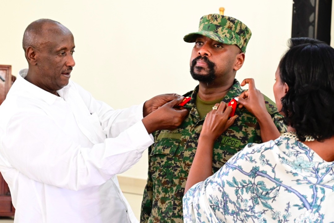 Gen Kainerugaba being decorated by his wife, Charlotte and Gen Salim Saleh
